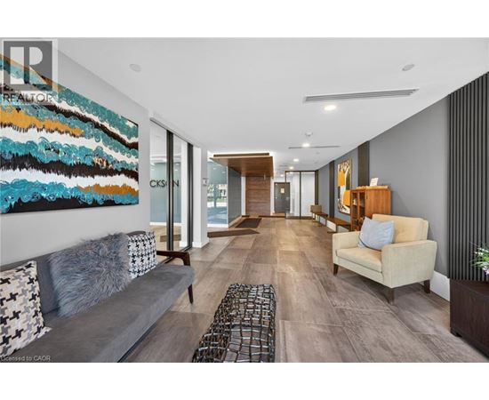 A modern living room with a large abstract painting on the wall.