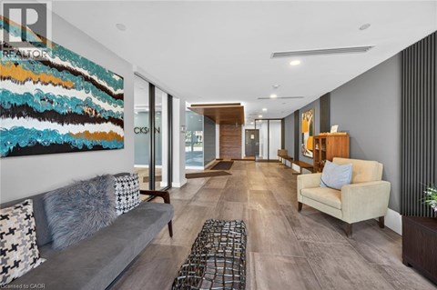 A modern living room with a large abstract painting on the wall.