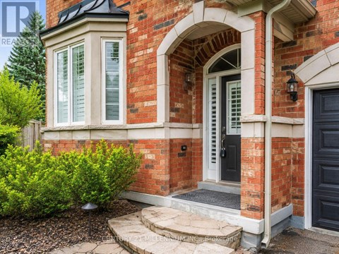A red brick house with a black door and a small window.
