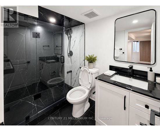 A bathroom with a toilet, sink, and mirror.
