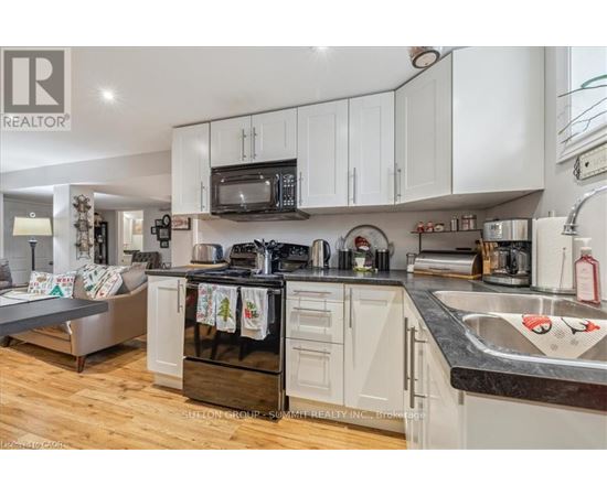 A kitchen with white cabinets and a black stove top oven.