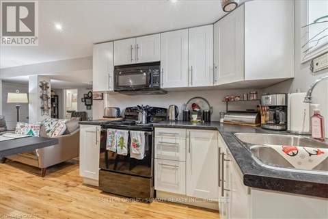 A kitchen with white cabinets and a black stove top oven.