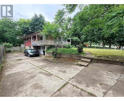 A car is parked in a driveway in front of a house.