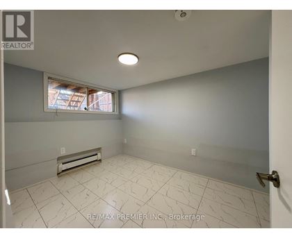 A room with a window and a tiled floor.