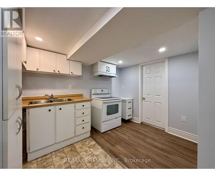 A kitchen with white cabinets and a wooden countertop.