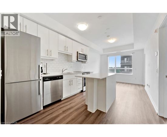 A modern kitchen with white cabinets and stainless steel appliances.