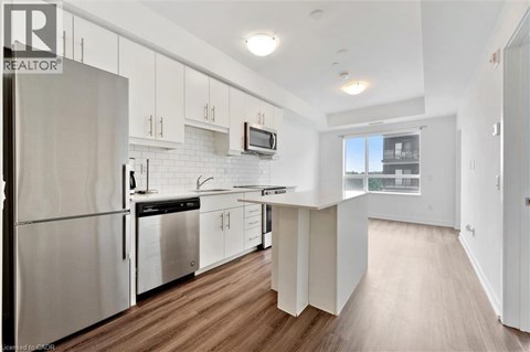 A modern kitchen with white cabinets and stainless steel appliances.