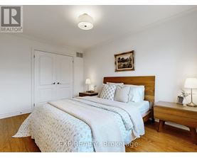 A bedroom with a large bed and a wooden nightstand.
