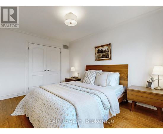 A bedroom with a large bed and a wooden nightstand.