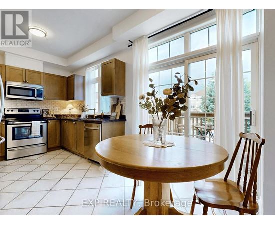 A kitchen with a table and chairs in the foreground and a balcony with a table and chairs in the background.