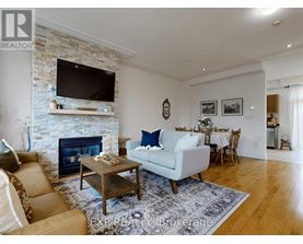 A living room with a fireplace and a flat screen TV mounted above it.
