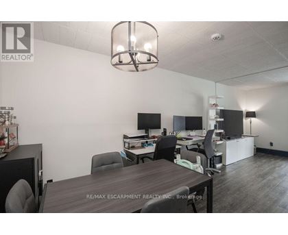 A conference room with a table, chairs, and a television.