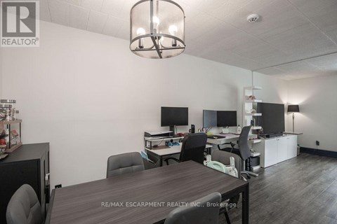 A conference room with a table, chairs, and a television.