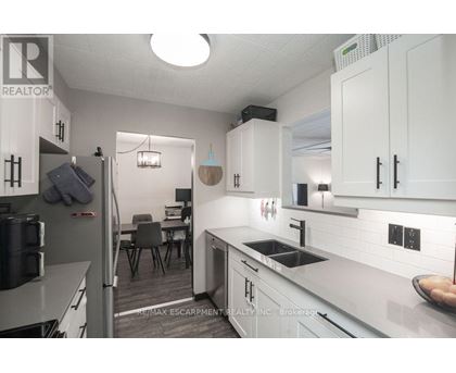 A kitchen with white cabinets and a grey counter top.