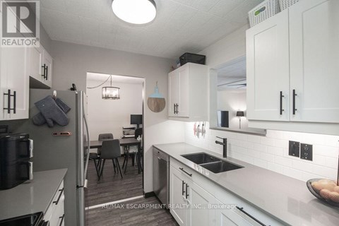 A kitchen with white cabinets and a grey counter top.