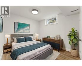 A bedroom with a bed, nightstands, and a plant.