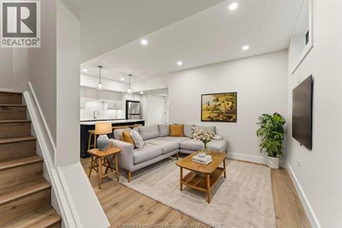 A living room with a couch, a coffee table, and a painting on the wall.