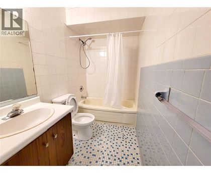 A bathroom with a white toilet, sink, and bathtub.
