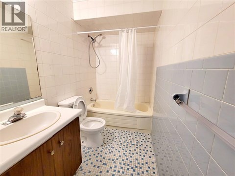 A bathroom with a white toilet, sink, and bathtub.