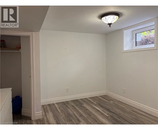 A room with a window and a wooden floor.