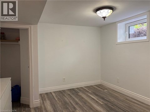 A room with a window and a wooden floor.