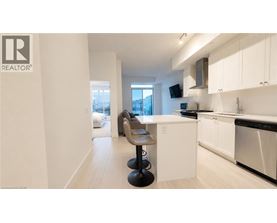 A modern kitchen with white cabinets and a black stove top oven.