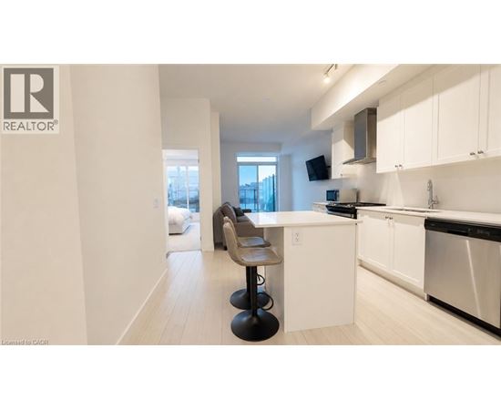 A modern kitchen with white cabinets and a black stove top oven.