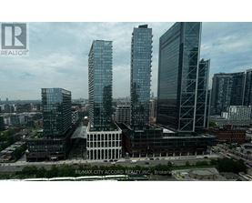 A cityscape with tall buildings and a cloudy sky.