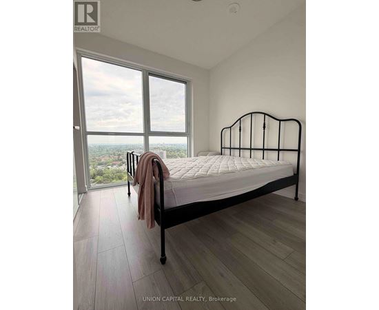 A bedroom with a large bed and a view of the city.