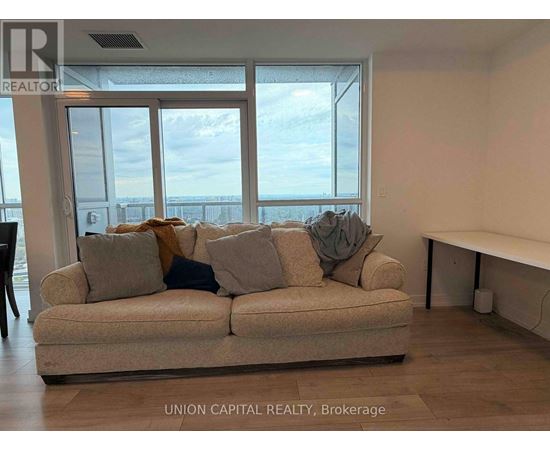 A living room with a couch and a view of the ocean through the windows.