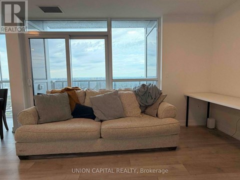 A living room with a couch and a view of the ocean through the windows.