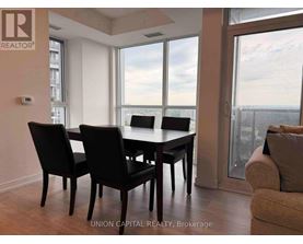 A dining room with a table and chairs and a view of the city.