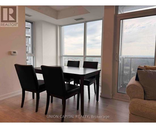 A dining room with a table and chairs and a view of the city.
