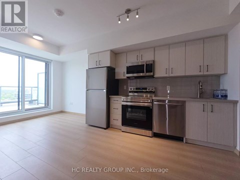 A kitchen with a refrigerator, oven, microwave, and cabinets.