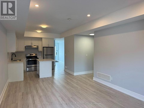 A spacious kitchen with white cabinets and a stainless steel oven.