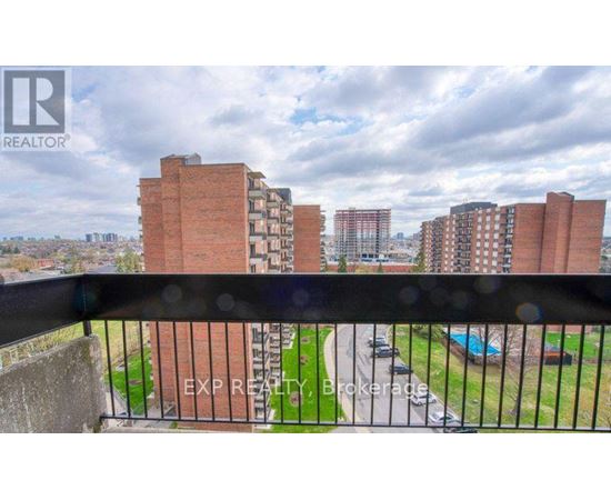 A view from a balcony overlooking a residential area with buildings and a pool.