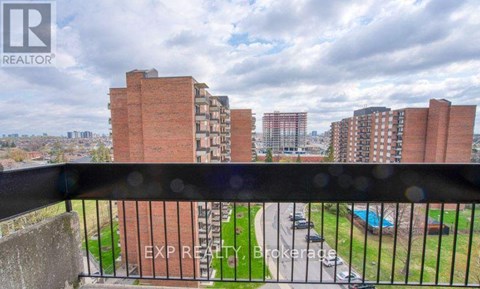 A view from a balcony overlooking a residential area with buildings and a pool.