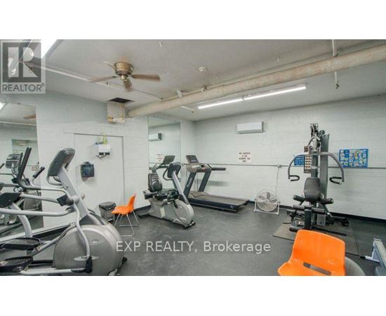A gym with treadmills, exercise bikes, and a fan.