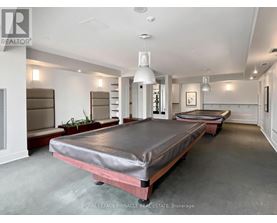 A bedroom with a bed in the center and a plant to the left.