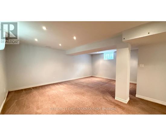 A brokerage sign is on the wall in a large empty room.