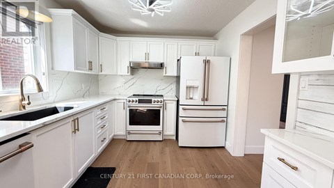 A kitchen with white cabinets and appliances.