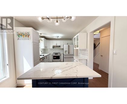 A kitchen with a marble countertop and a logo on the fridge.