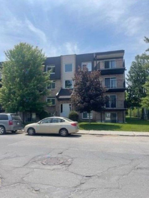 A car is parked in a parking lot in front of a building.