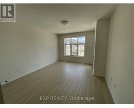 A room with wooden flooring and a window with a view of a building outside.