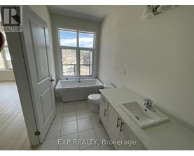 A bathroom with a tub, toilet, and sink.