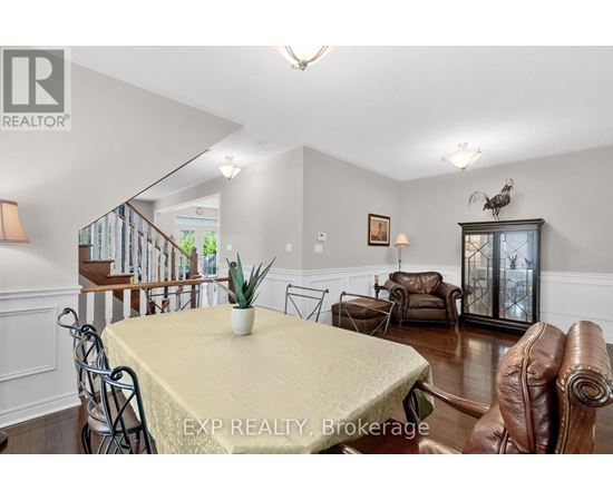 A dining room with a table set for two and a couch.