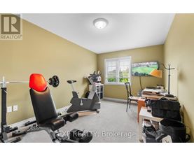 A home gym with a treadmill, weights, and exercise equipment.