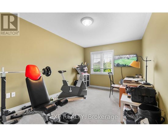 A home gym with a treadmill, weights, and exercise equipment.