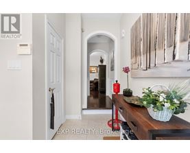 A hallway with a wooden bench and a basket of flowers.