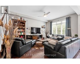 A living room with black leather sofas and a wooden floor.